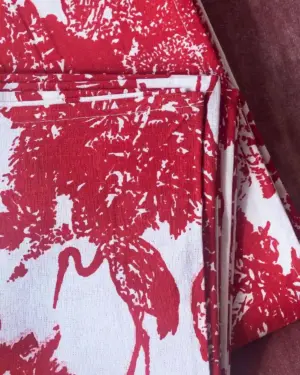 Mantel de algodón Garza Roja con estampado tropical de garzas y vegetación en rojo sobre fondo blanco.