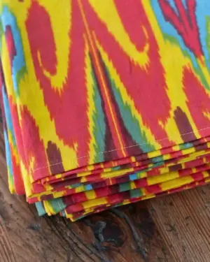Detalle del mantel Ikat multicolor de algodón con estampado étnico en tonos amarillo, rojo, turquesa y verde de Cassai.