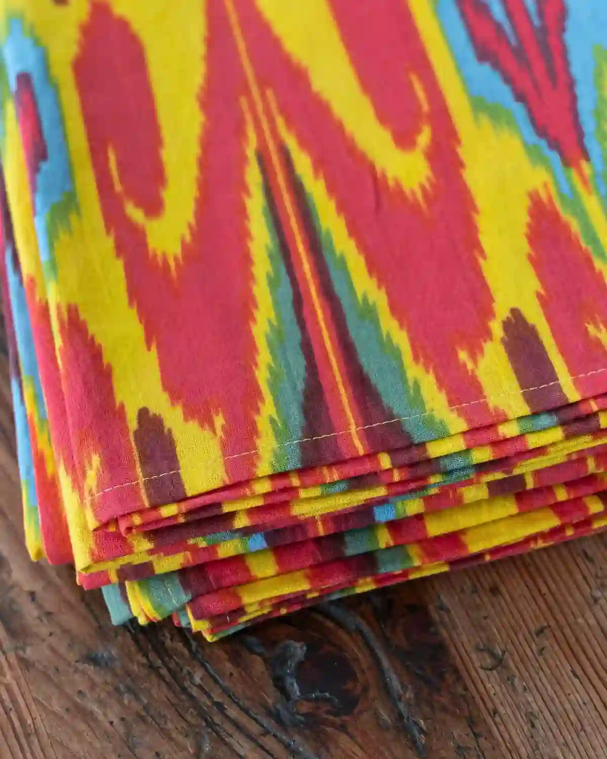 Detalle del estampado Ikat multicolor, un diseño vibrante que llena la mesa de energía y estilo.