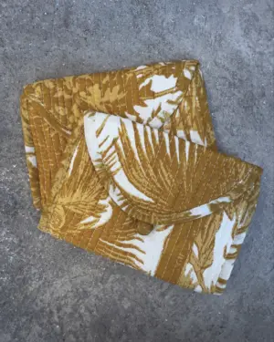 monedero de tela acolchado para mujer con estampado de palmeras en color mostaza