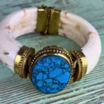 Brazalete azul negro mate con piedra sintética turquesa veteada en negro engarzada en latón dorado y estructura de hueso sintético blanco, hecho a mano en India