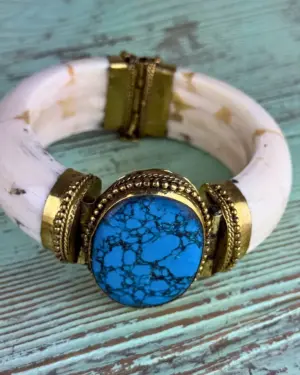 Brazalete azul negro mate con piedra sintética turquesa veteada en negro engarzada en latón dorado y estructura de hueso sintético blanco, hecho a mano en India