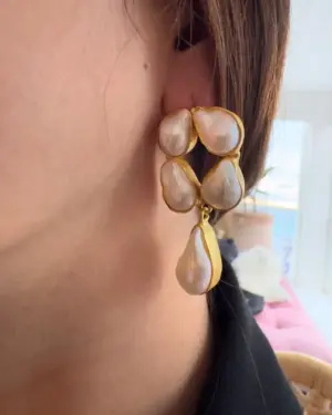 Pendientes de perla barroca dorada para mujer puestos en oreja con diseño elegante y artesanal
