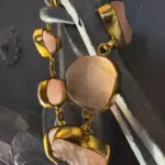 Pulsera de cuarzo rosa con baño de oro en composición vertical mostrando piedras naturales y acabado artesanal