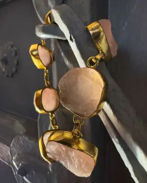 Pulsera de cuarzo rosa con baño de oro en composición vertical mostrando piedras naturales y acabado artesanal