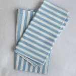 Servilletas de tela con rayas azul y blanco de The Collection 2025 diseñada por Catalina Socias para Cassai Mallorca