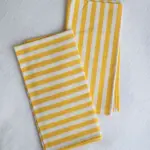 Servilletas de tela con rayas amarillo y blanco de The Collection 2025 diseñada por Catalina Socias para Cassai Mallorca
