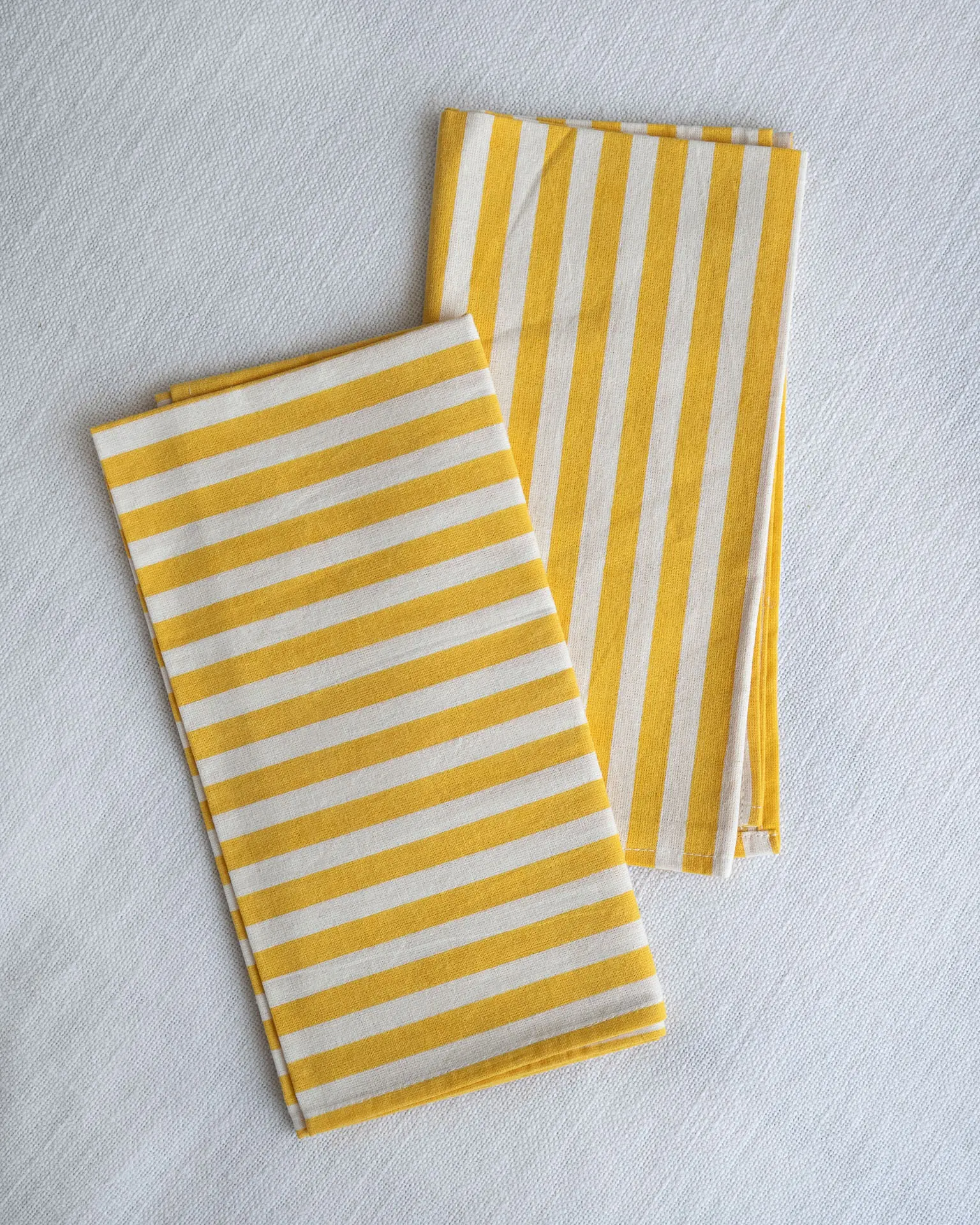 Servilletas de tela rayadas amarillo y blanco de The Collection 2025 by Catalina Socias, diseño exclusivo para Cassai Mallorca.