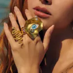 Anillo dorado grande Ojos de Zeus con diseño irregular y ojo azul central estilo statement ring en joyería de mujer