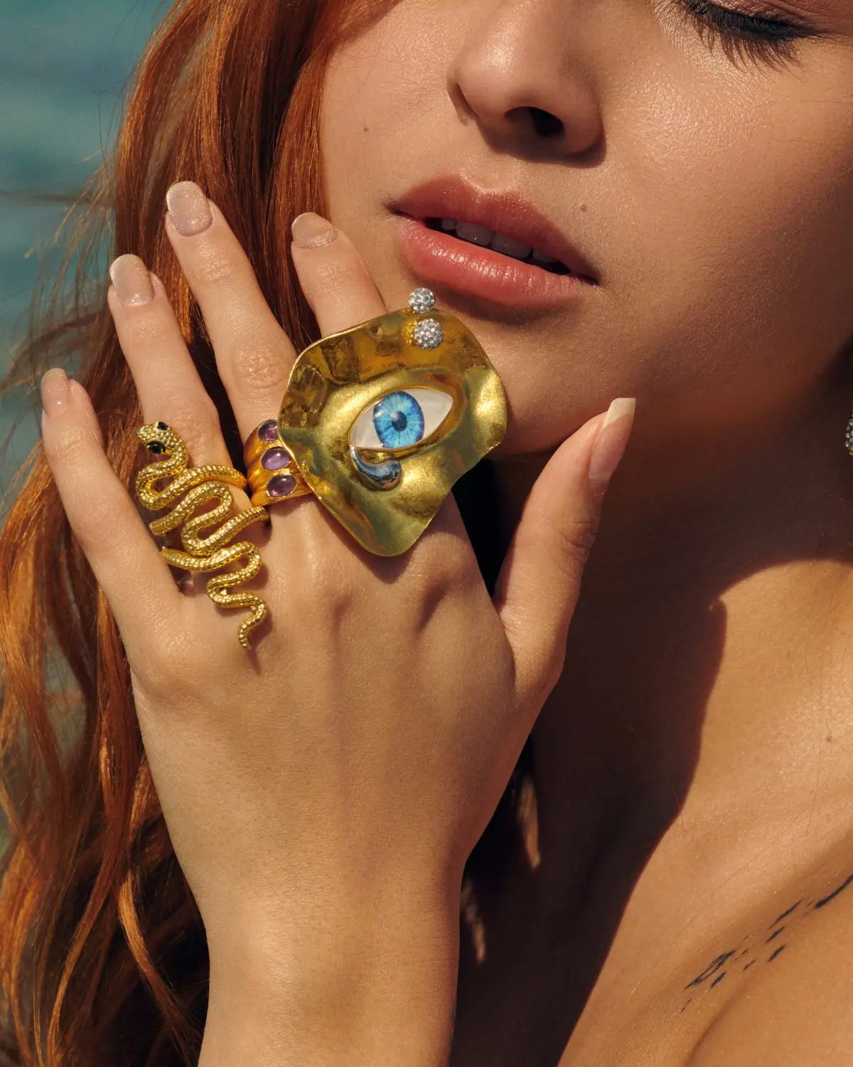 Anillo dorado grande Ojos de Zeus con diseño irregular y ojo azul central estilo statement ring en joyería de mujer