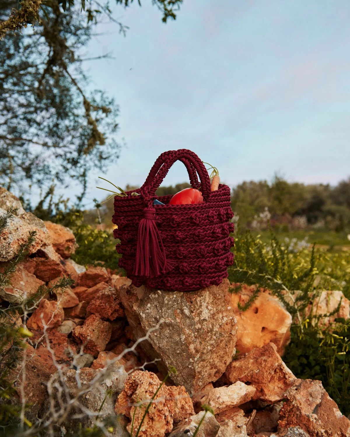 Bolso crochet granate con borla elaborado artesanalmente en tono burdeos estilo mediterráneo