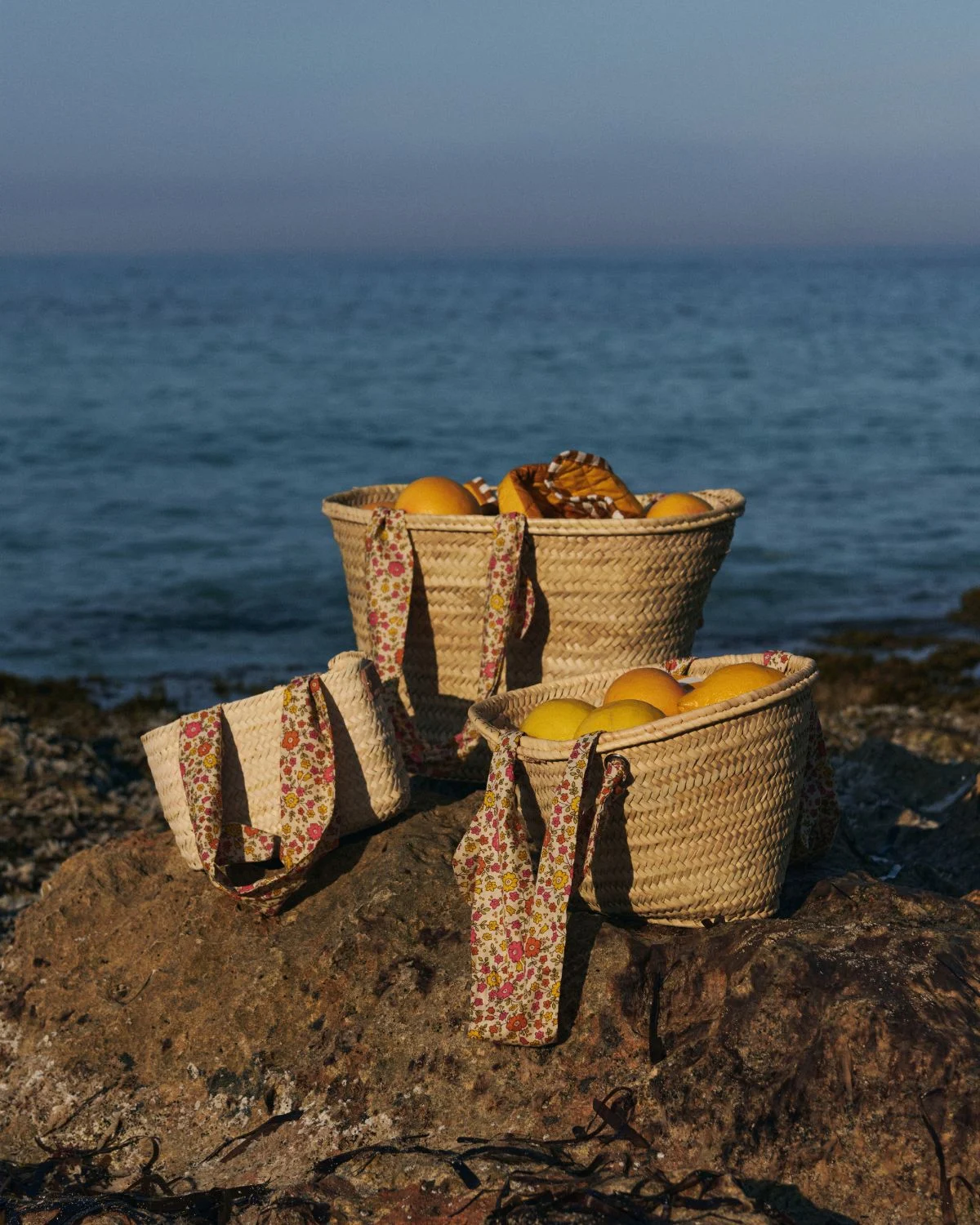 Cesta de palmito mediana con asas florales, una pieza artesanal de inspiración mediterránea con tamaño equilibrado y estilo natural.