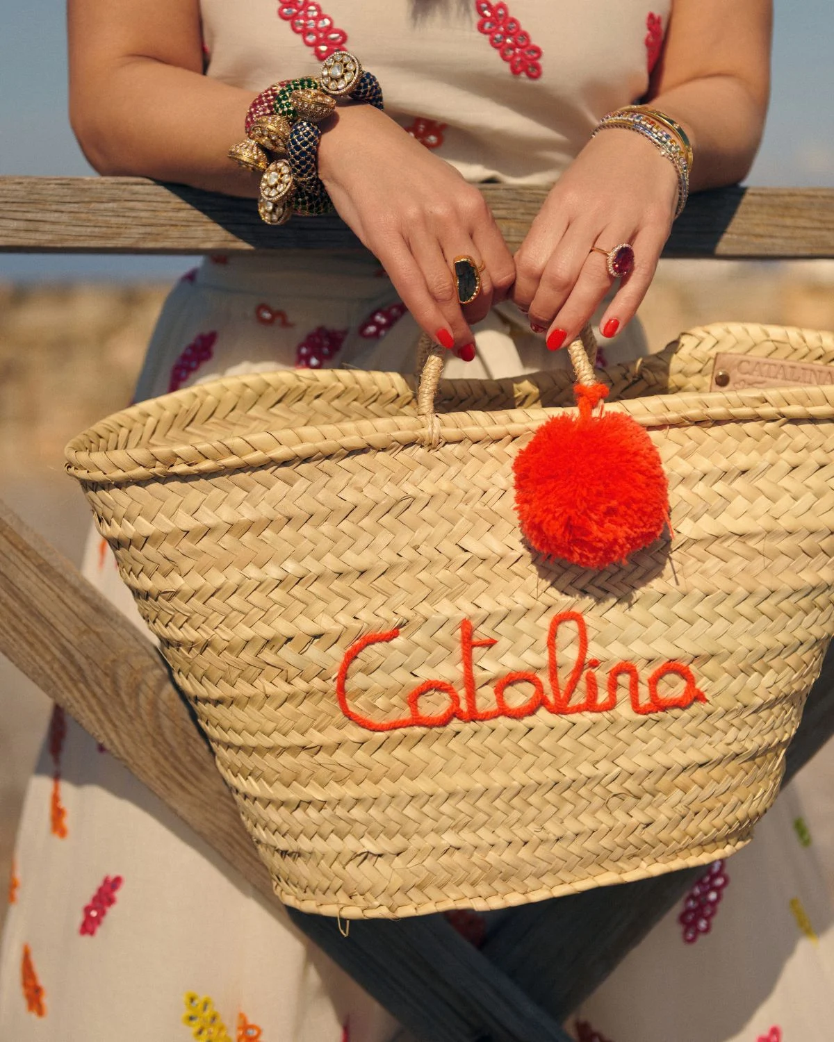 El detalle del bordado y el pompón resalta el carácter artesanal de esta cesta mediterránea.