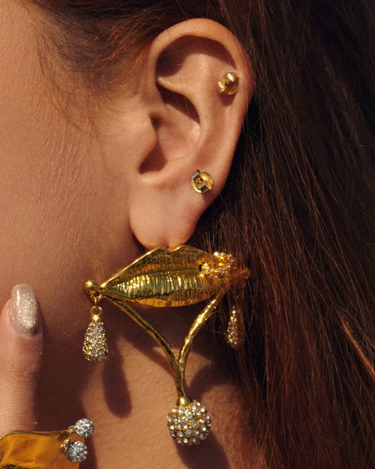 Pendientes dorados con diseño de labios y detalles brillantes estilo statement en joyería de mujer
