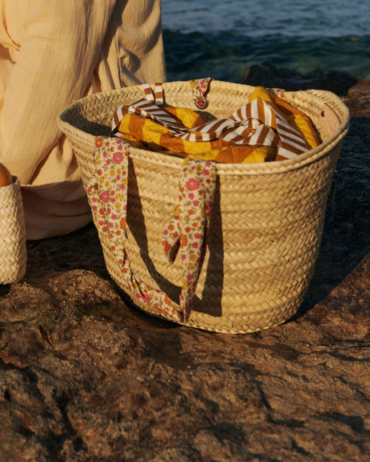 Detalle de cesta de palmito grande con asas florales, una pieza artesanal amplia y natural inspirada en el estilo mediterráneo.