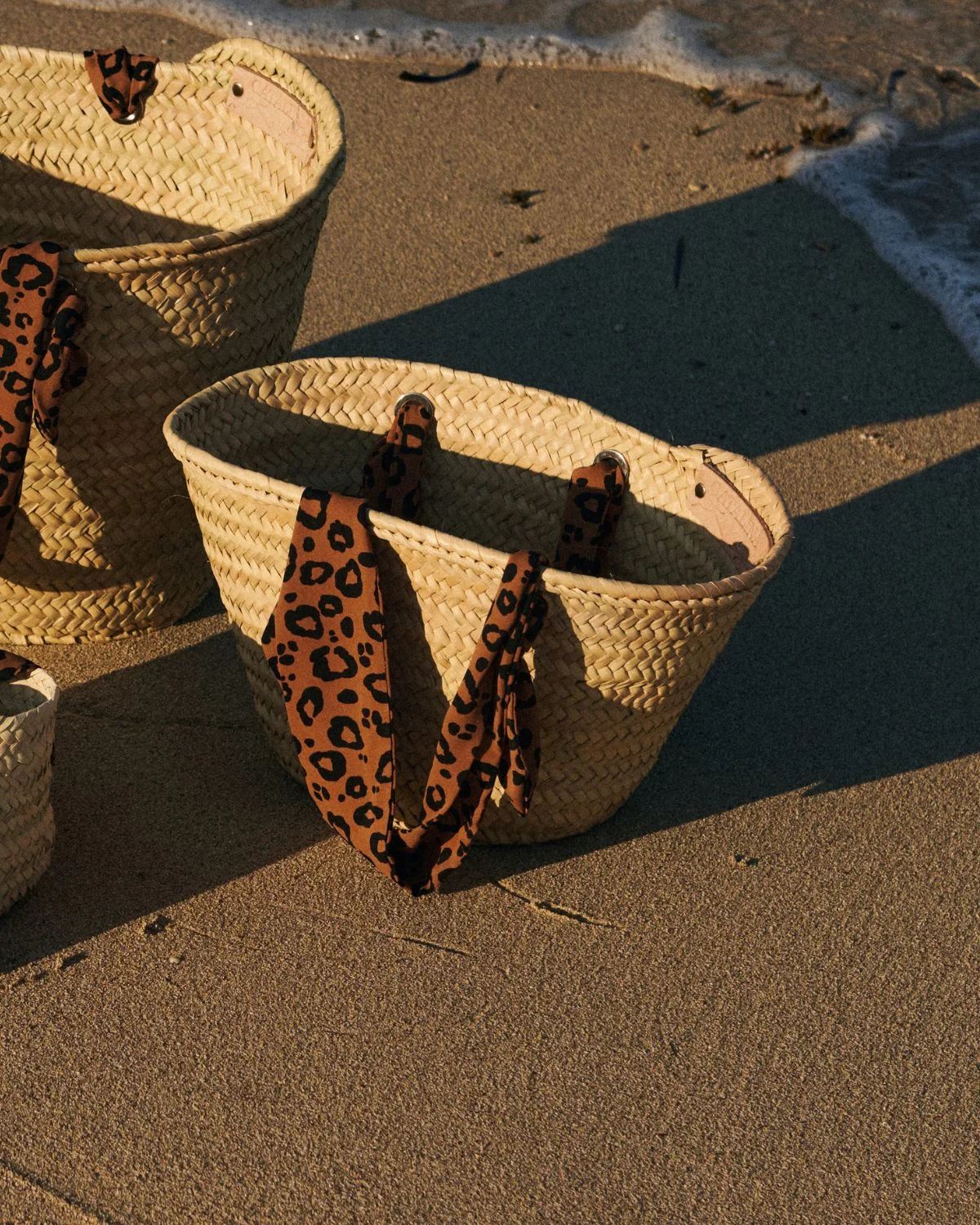 Cesta de palmito mediana con asas animal print, un bolso de verano versátil que combina naturalidad y estilo mediterráneo.