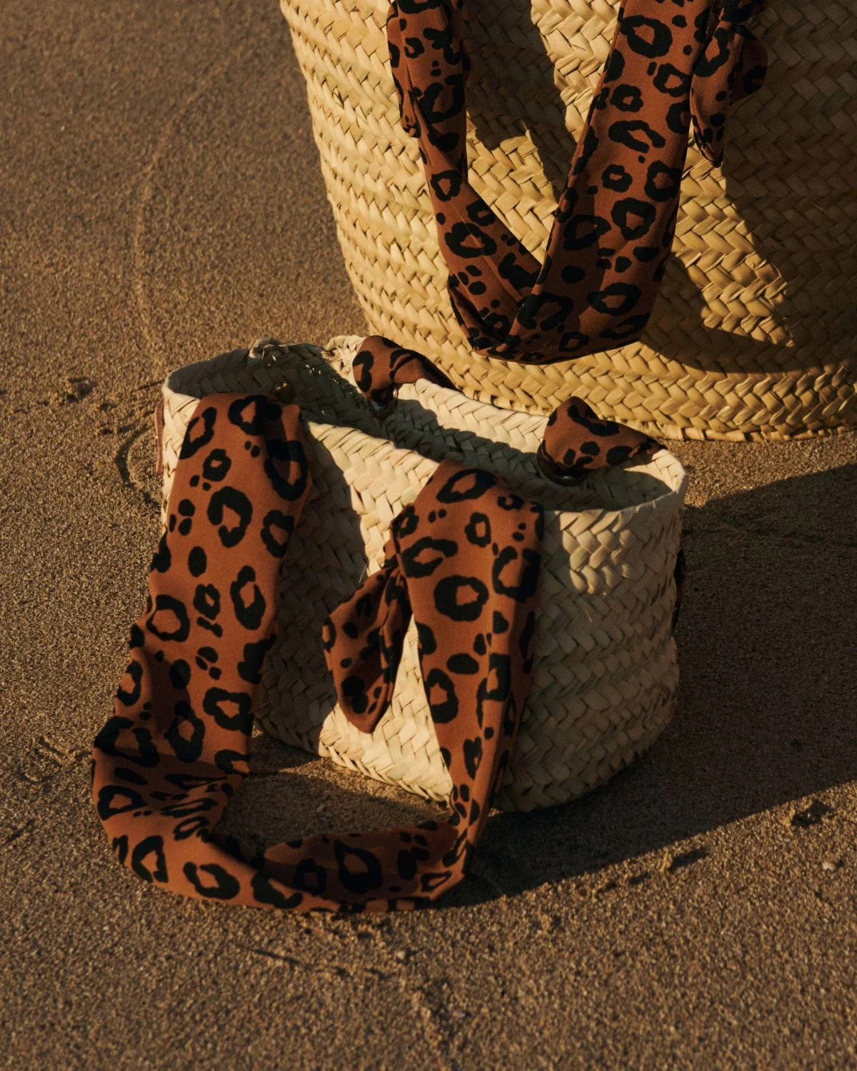 Cesta de palmito pequeña con asas animal print, un bolso compacto y versátil ideal para verano con estilo mediterráneo.