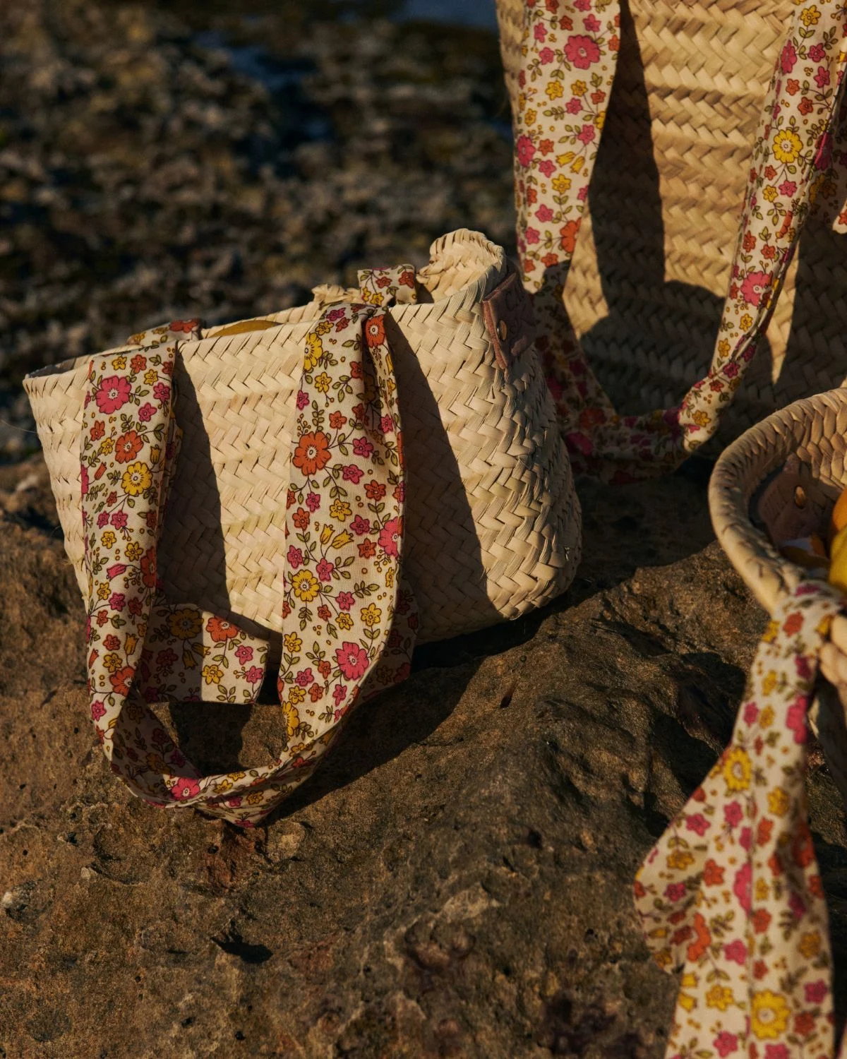 Cesta de palmito pequeña con asas florales, una pieza compacta y artesanal de inspiración mediterránea.