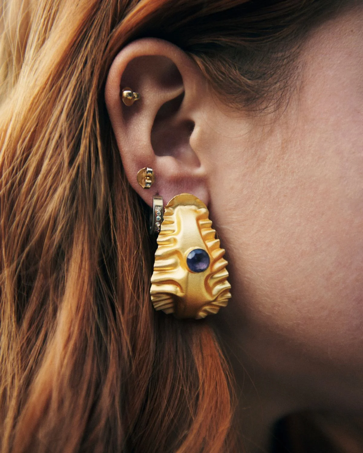 Pendientes dorados de diseño Ala dorada central, una pieza de joyería contemporánea con carácter artístico.