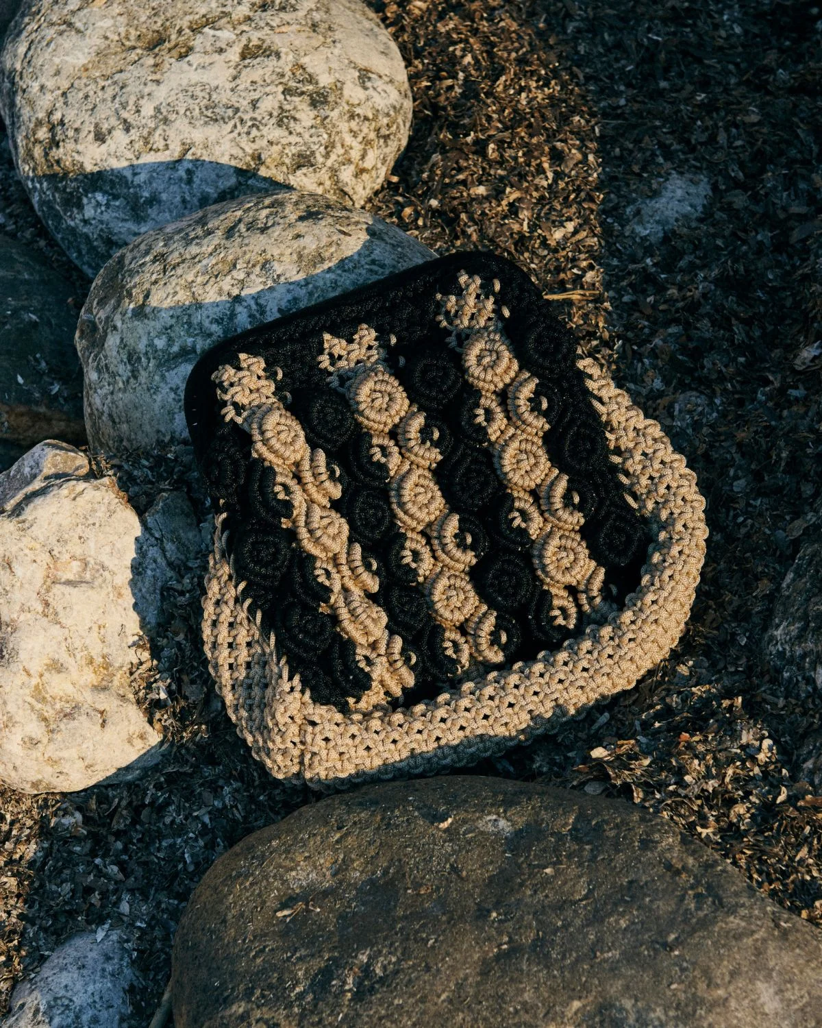 Bolso de crochet bicolor beige y negro con nudos texturizados estilo artesanal