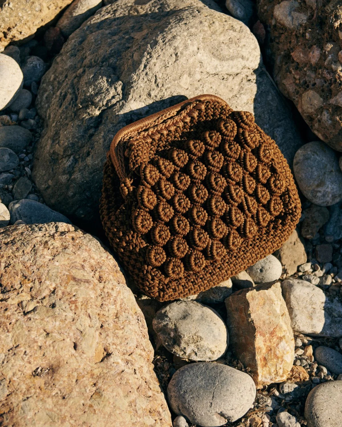 Bolso de crochet marrón con nudos artesanales, una pieza compacta con inspiración natural y mediterránea.