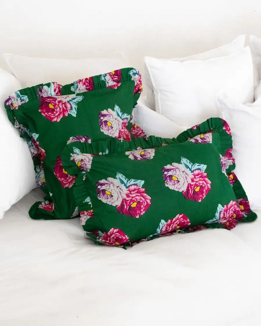 Cojín floral verde con volantes, ideal para decoración elegante de dormitorio