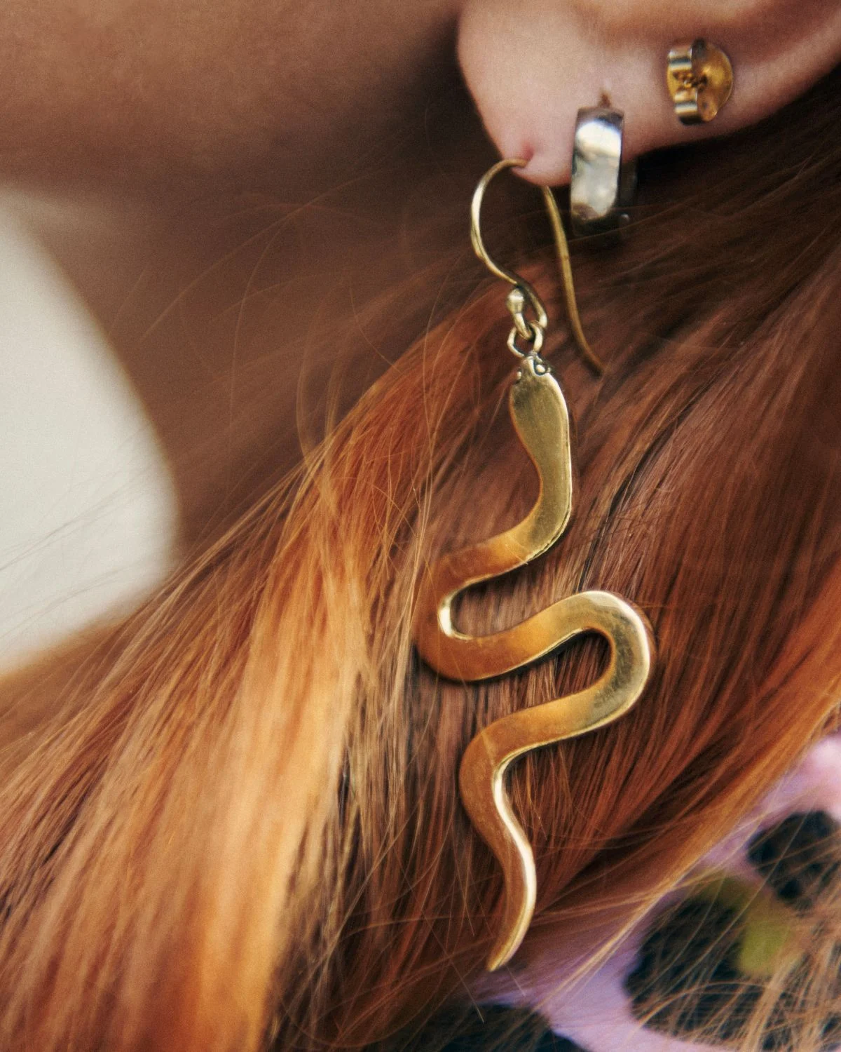 Pendientes Serpiente Luz dorados, una pieza estilizada que simboliza transformación y elegancia.