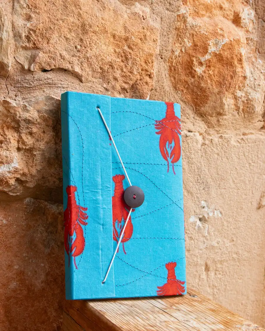 Agenda decorativa de tamaño mediano con estampado de langosta capri en tonos turquesa y rojo. Diseñada para organizar el día con estilo mediterráneo y funcionalidad.