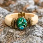 Brazalete Turquesa Mediterránea artesanal con piedra verde turquesa y detalles dorados sobre rocas naturales