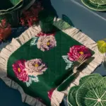 Mantel individual verde con estampado floral sobre mesa decorada estilo mediterráneo