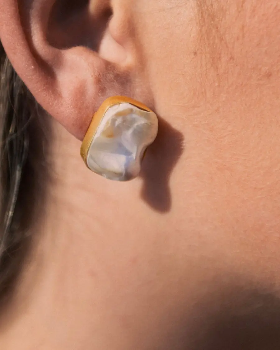 Pendientes de nácar natural con forma cuadrada irregular y montura bañada en oro. Un diseño elegante inspirado en la luz del Mediterráneo.