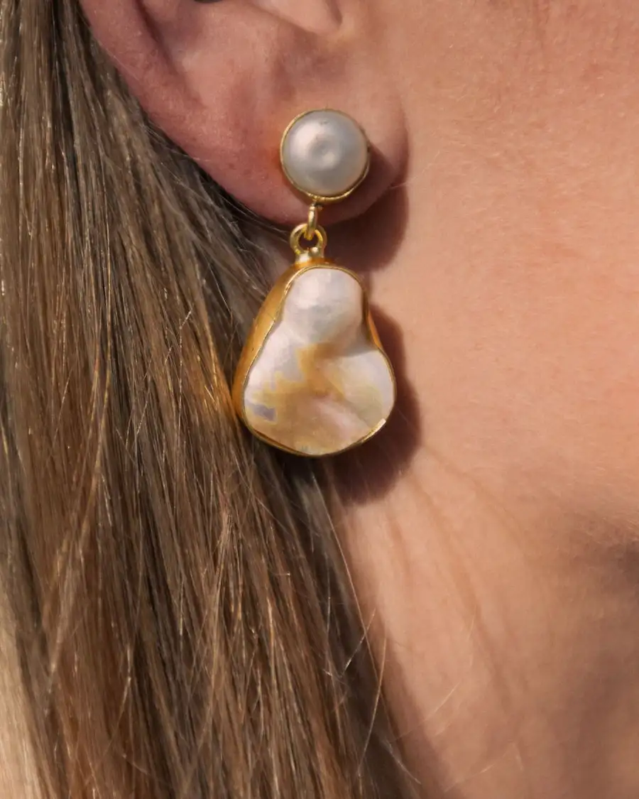 Pendientes de nácar natural y latón bañado en oro inspirados en la luz y la elegancia del Mediterráneo.