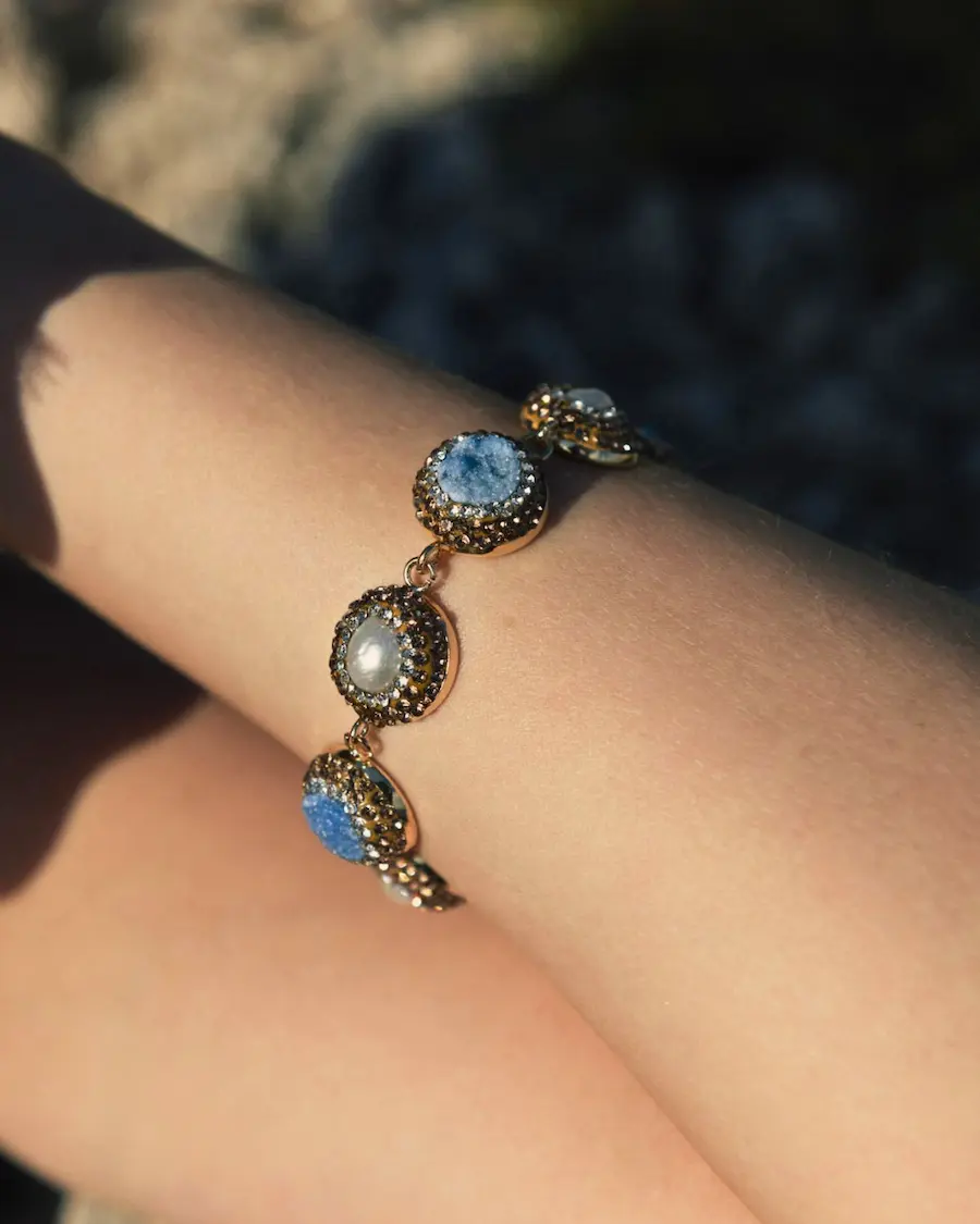 El Brazalete Bruma Marina Cassai Home combina cristales efecto druzy en tonos azul mediterráneo, detalles perlados y un delicado micro pavé para crear una joya elegante inspirada en el mar.