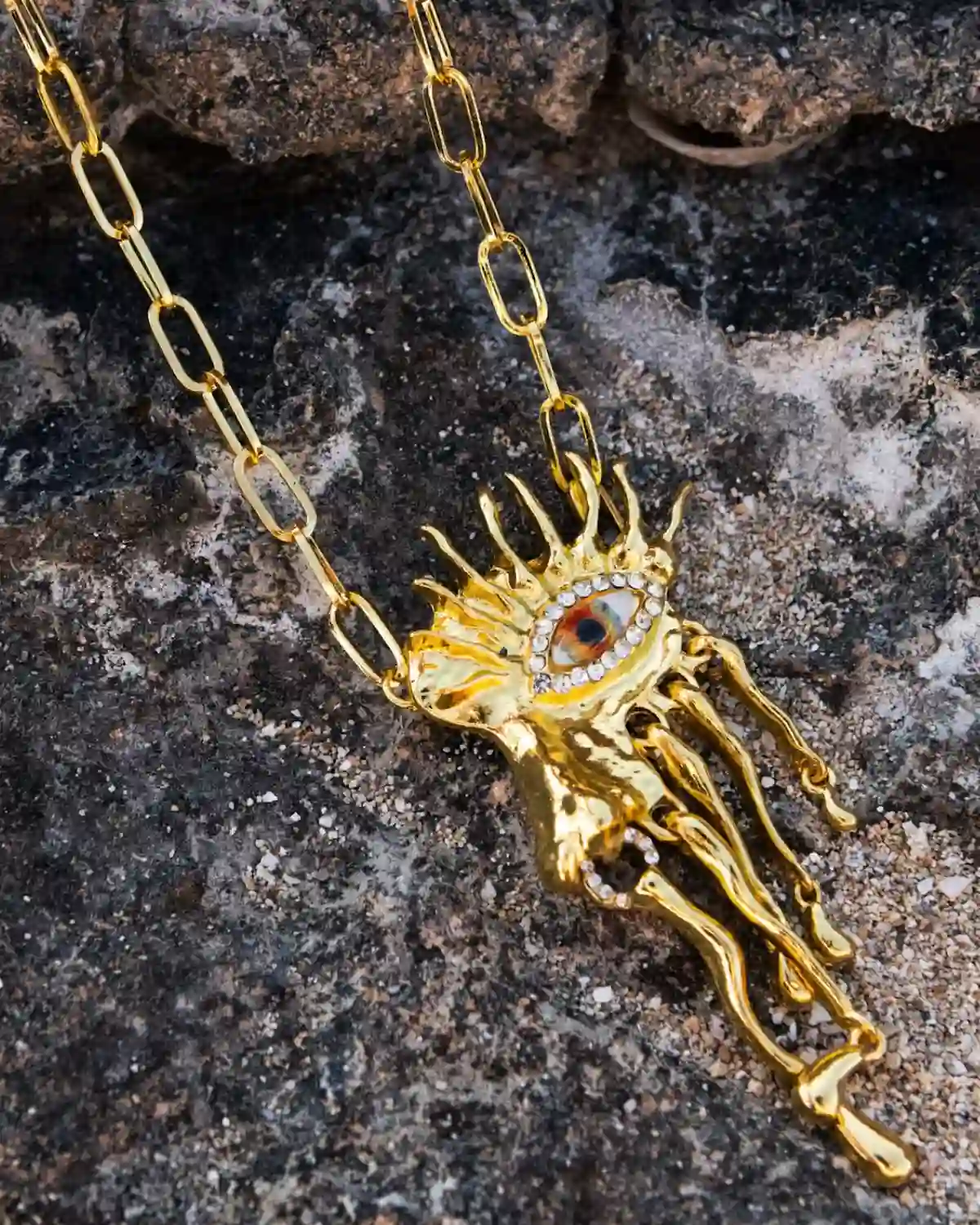 El Collar Helios Mediterráneo combina un ojo protector pintado a mano, cristales y latón dorado en una joya escultórica inspirada en el Mediterráneo.