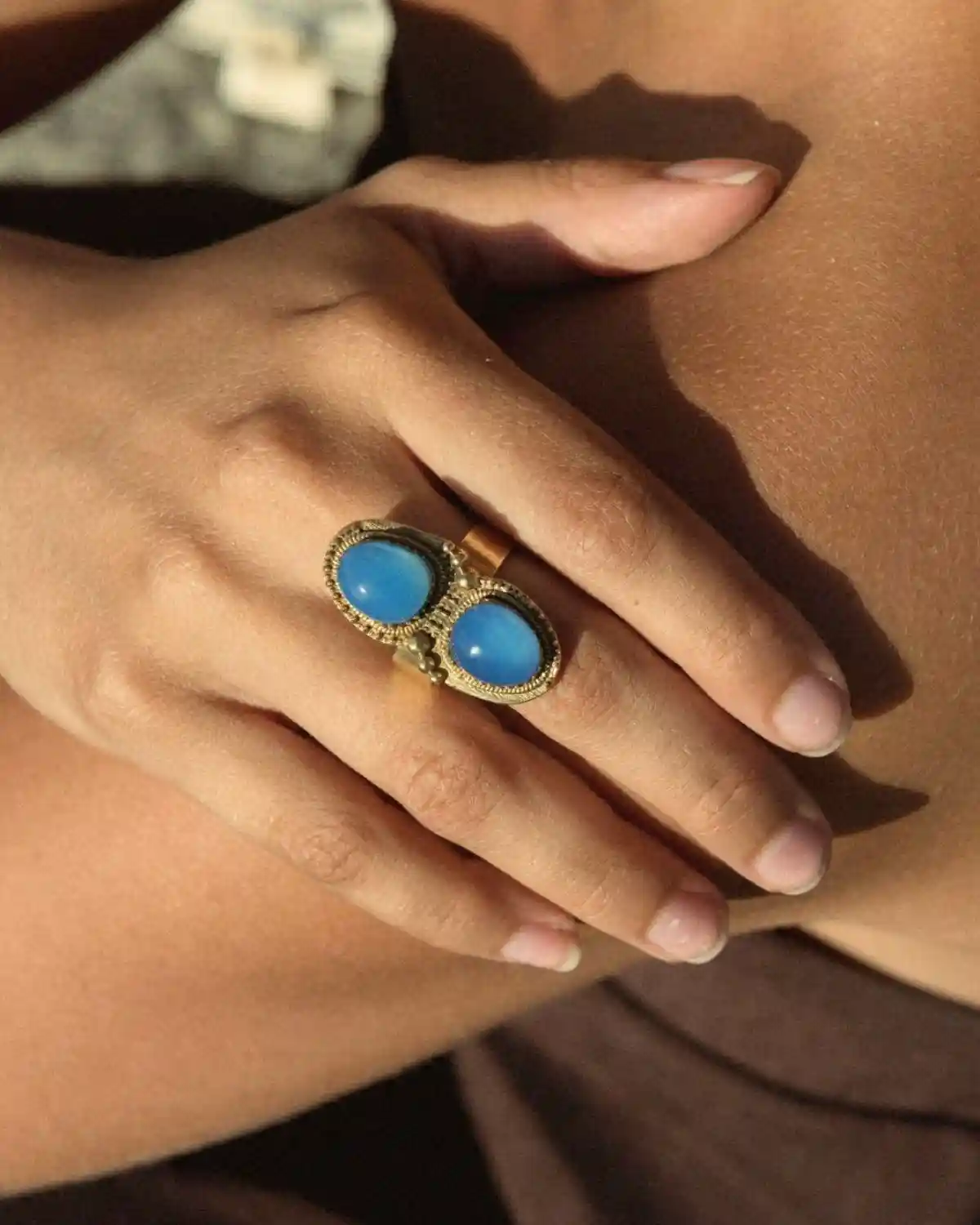 El Anillo Doble Egeo Mediterráneo combina dos cabujones azules sobre una montura de inspiración vintage, convirtiéndose en el complemento perfecto para looks de verano y estilo mediterráneo.