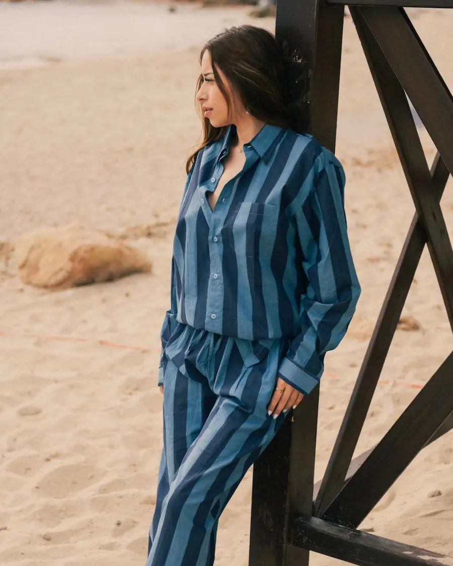 La Camisa Manga Larga Rayas Mujer Azul Marino combina un diseño oversize unisex, algodón ligero y rayas verticales para crear un look elegante inspirado en el estilo de vida mediterráneo.