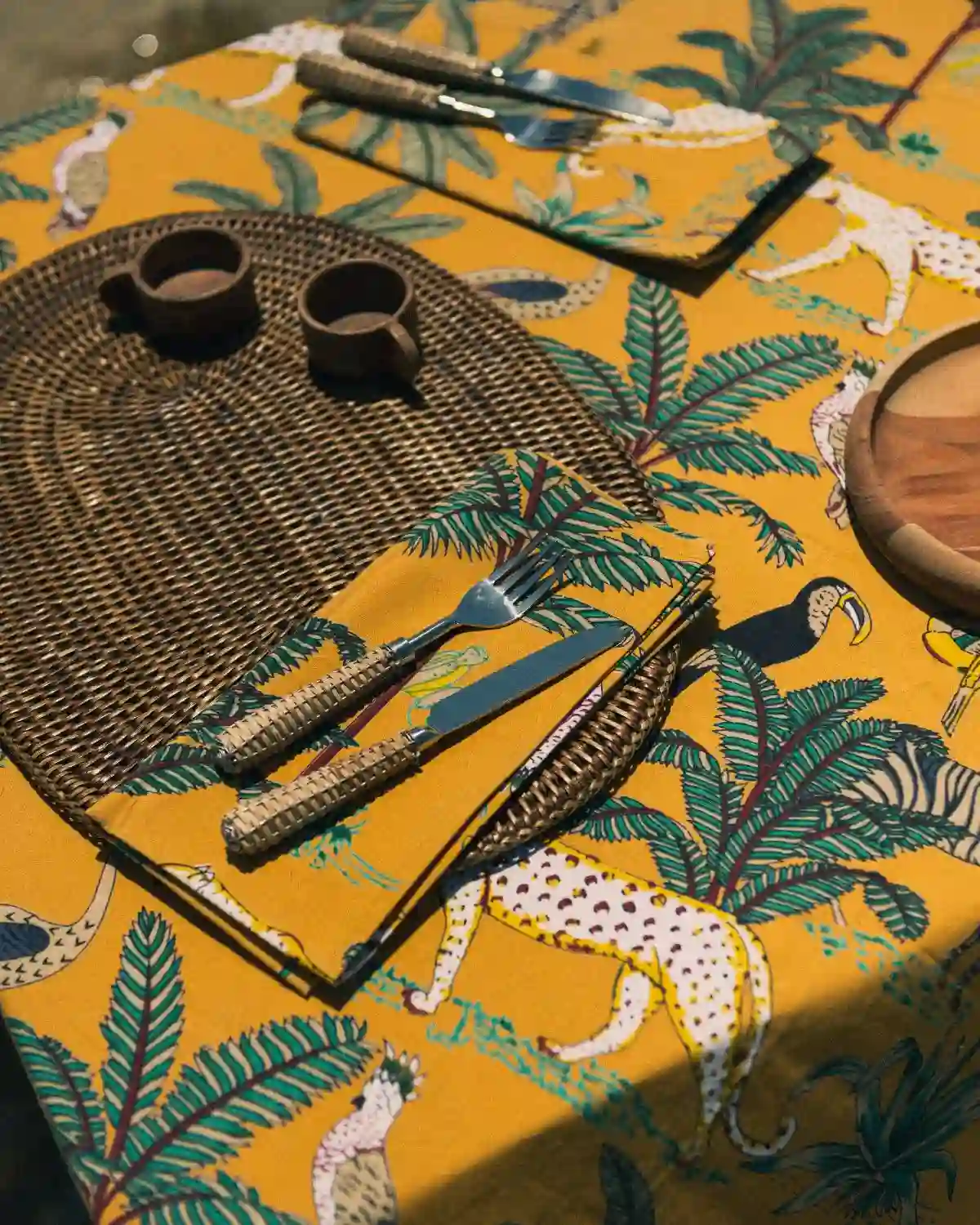 La combinación de mantel y servilletas crea una mesa armoniosa, elegante y con un marcado carácter tropical.