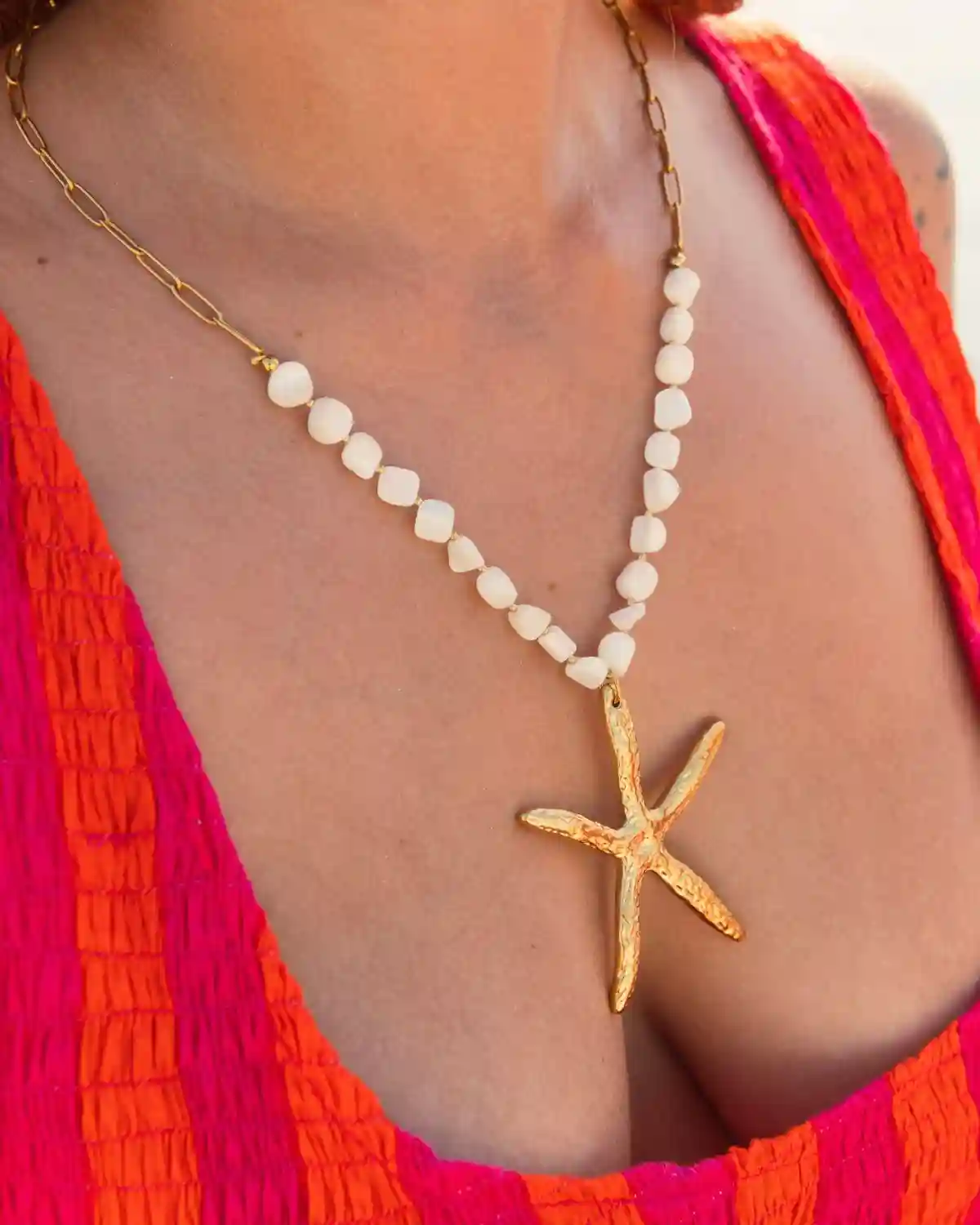Collar con estrella de mar en pan de oro y cuentas blancas de la Colección Catalina 2026.