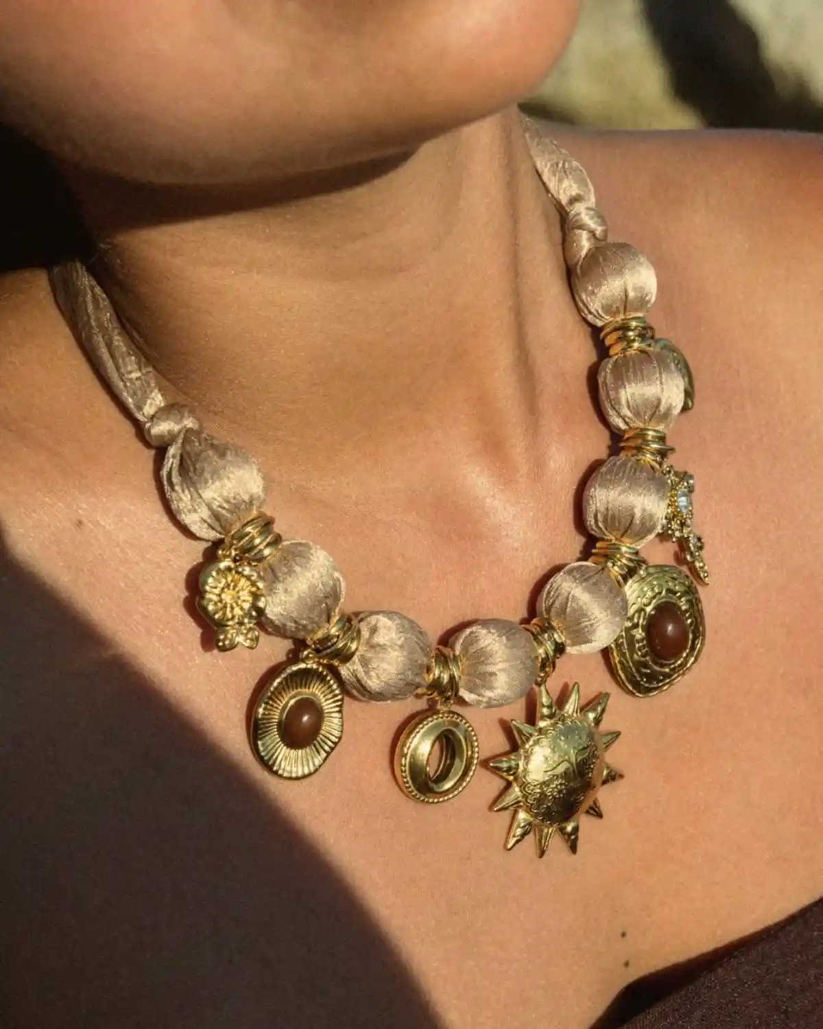 Collar Sol de Cala con cuentas de tela champán y charms dorados de la Colección Catalina 2026.