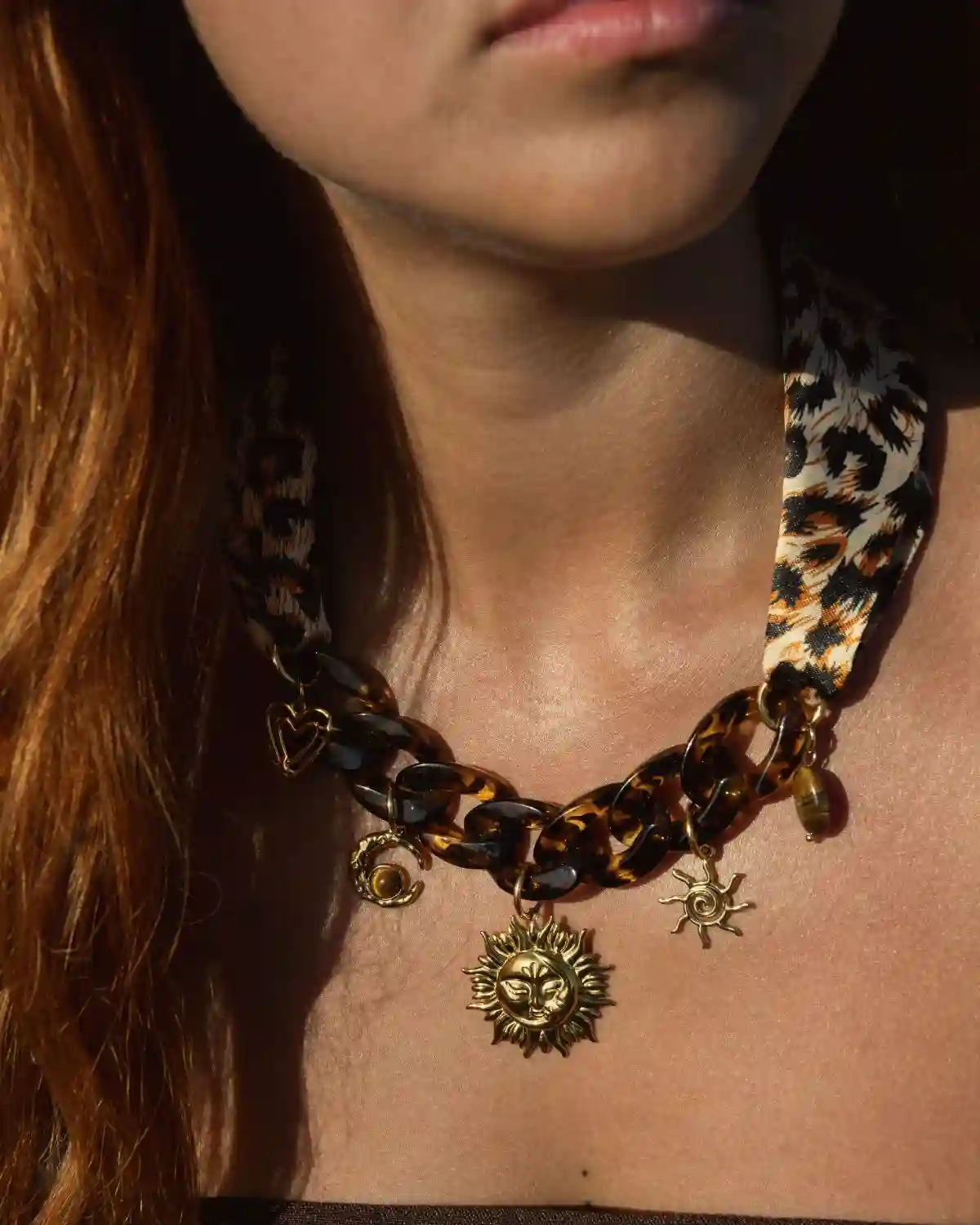 Collar Sol de Sóller con eslabones efecto carey, cinta de tela animal print y charms dorados.