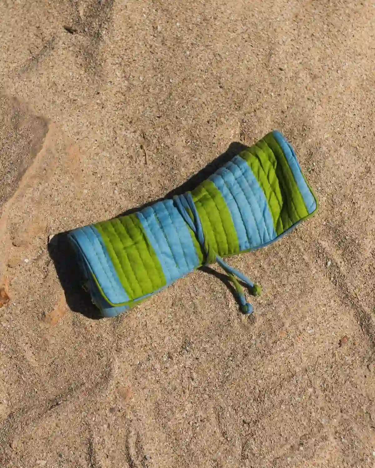 Bolsa de maquillaje acolchada Rayas Capri con diseño enrollable y cordón a juego.