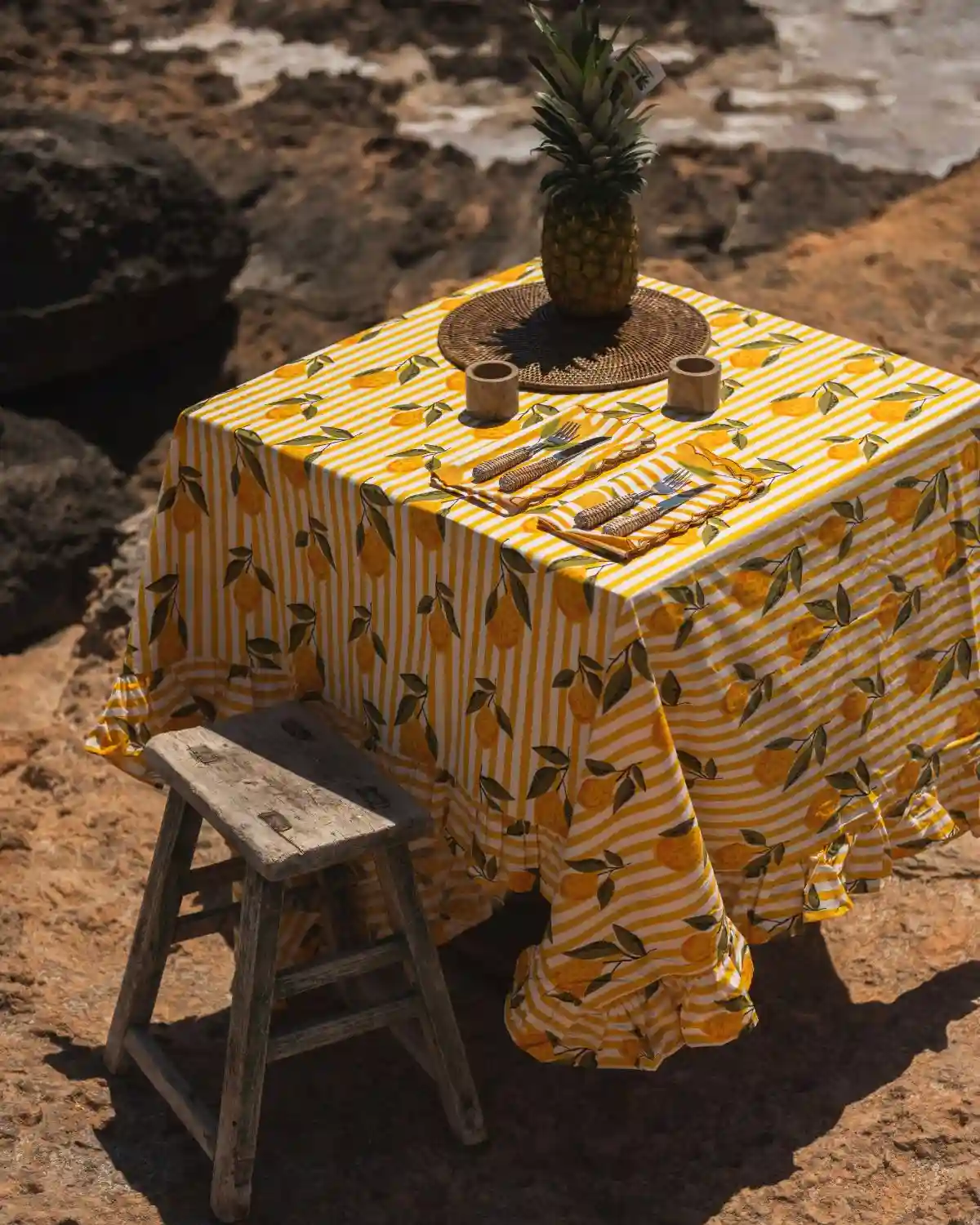 Una mesa mediterránea al aire libre vestida con el Mantel Rayas Limón.
