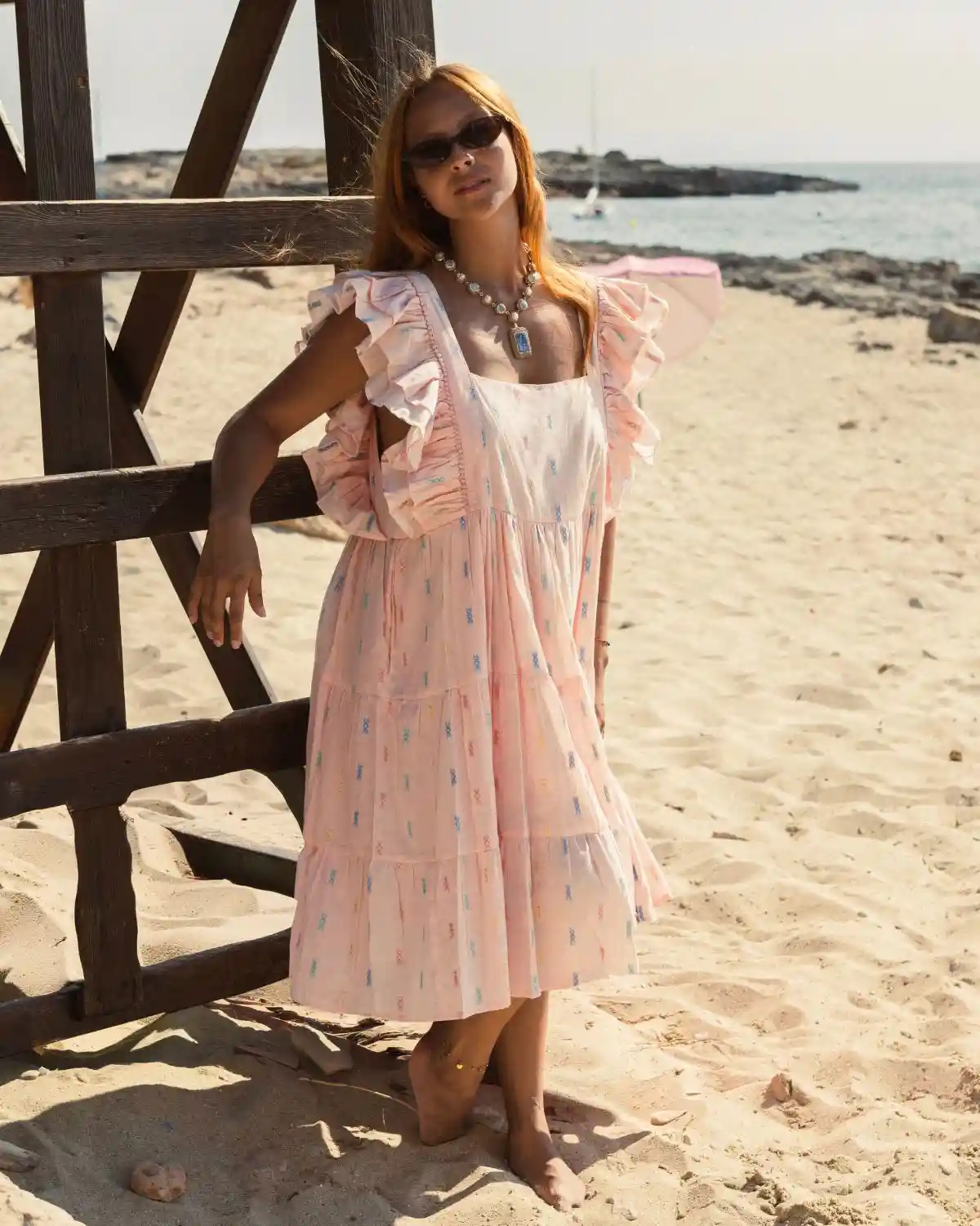 Vestido midi rosa empolvado con microestampado multicolor y mangas con volantes, inspirado en el estilo de vida mediterráneo.