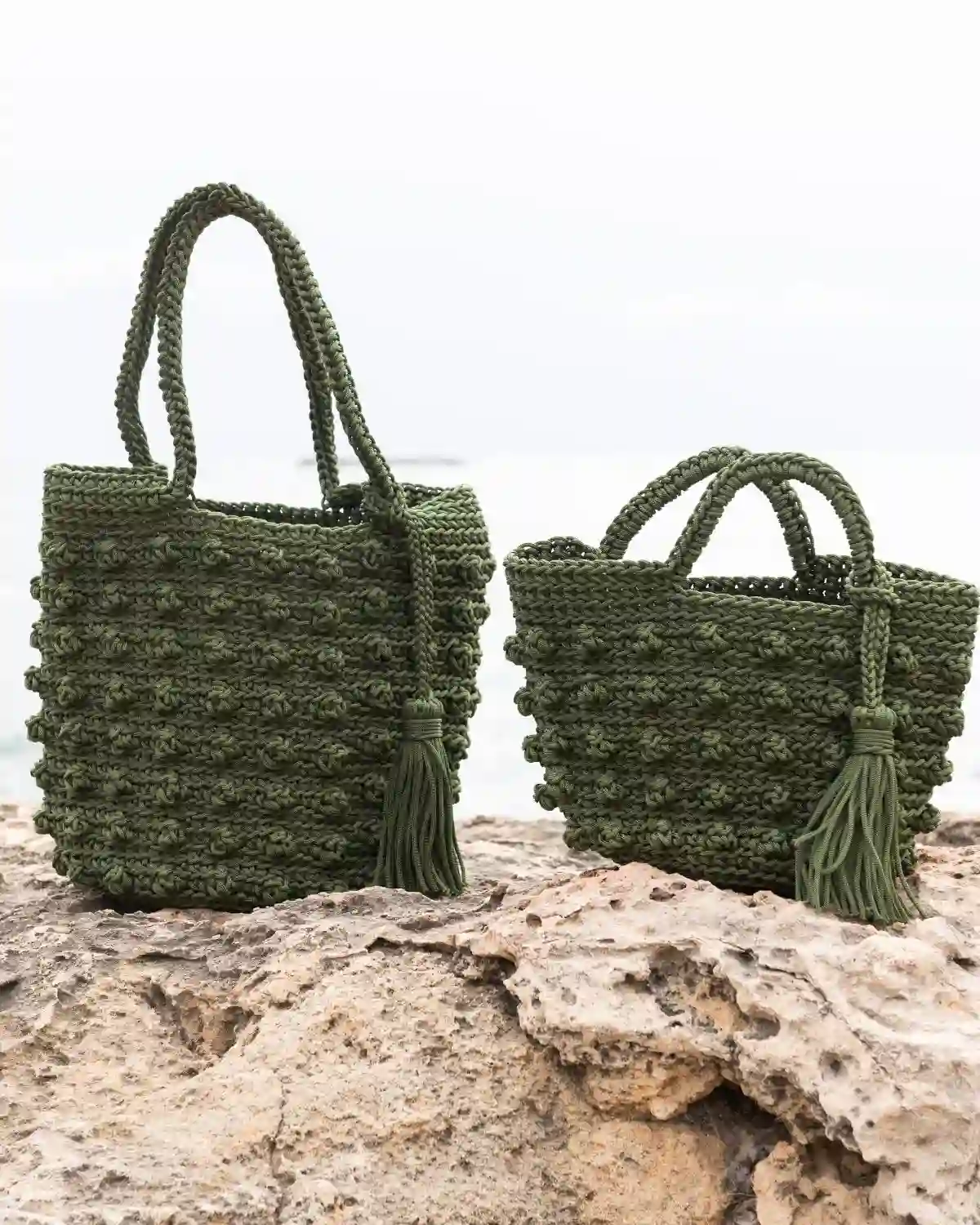 Bolso crochet verde oliva con tejido de nudos y borla, disponible en tallas M y L.