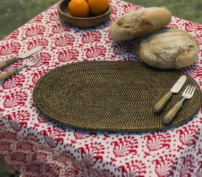 El mantel Garza Roja de Cassai combina un sofisticado estampado inspirado en garzas, palmeras y vegetación tropical en una intensa combinación de rojo y blanco. Presentado en un entorno costero, aporta carácter, luminosidad y un aire mediterráneo a mesas de terraza, jardín o junto al mar.